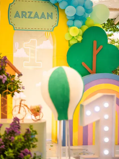 A detailed shot of the decor, including a hot air balloon prop, a light-up number '1', and a rainbow-colored arch.