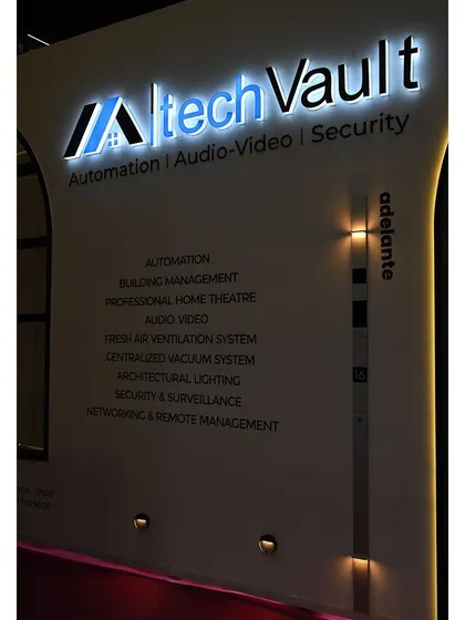 A close-up of our illuminated company logo and the list of services we offer, displayed at our exhibition booth. We provide a comprehensive range of solutions, from automation and building management to architectural lighting and security.