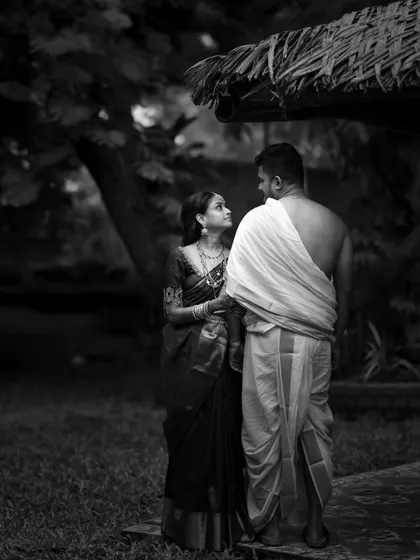 A classic black and white frame. The simplicity of their traditional attire and the natural setting creates a powerful, timeless image focused purely on their shared gaze.
