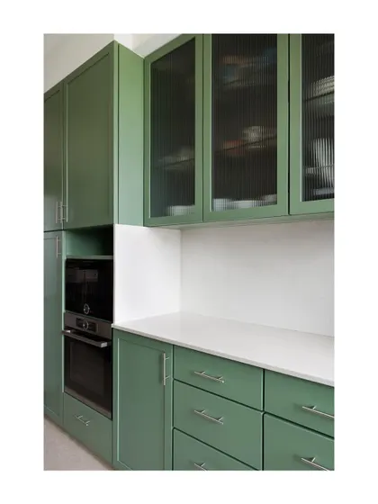 Custom kitchen cabinetry painted in a soft, sage green. I designed this kitchen with a mix of solid doors, drawers, and fluted glass uppers to provide a variety of storage options that are both functional and beautiful.