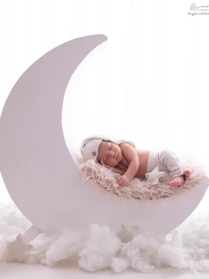 I love getting creative in my studio. Here, a sweet newborn dreams peacefully on a crescent moon prop, surrounded by soft clouds, creating a truly magical and whimsical portrait.