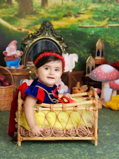 A beautiful portrait of our little Snow White sitting in a rustic crib, surrounded by her forest friends and a magical mirror.
