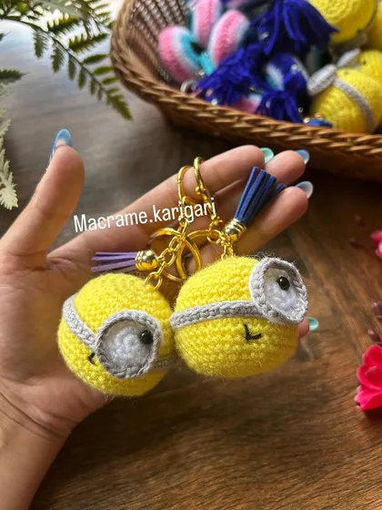 Holding a pair of our Minion keychains. They are lightweight and the perfect size to add to your collection without being bulky. We love how their cheerful yellow brightens up the day.