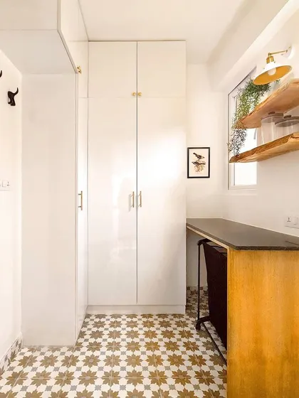 The adjoining maid's room was converted into a linen closet and laundry folding area. I included floor-to-ceiling cabinetry, a countertop for folding, and open shelves to add character and hold supplies.