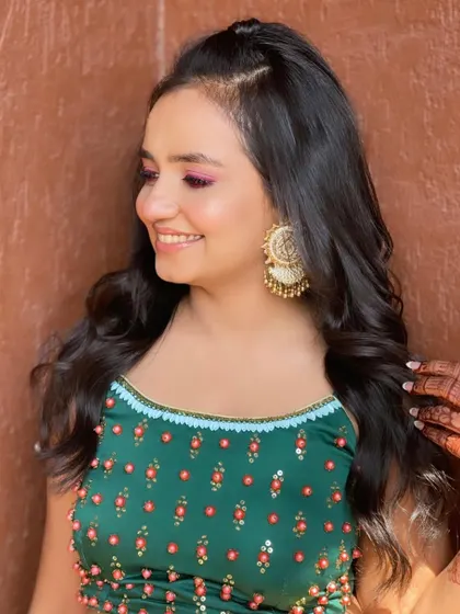 A portrait of the happy bridesmaid, her hair styled to complement her festive outfit.