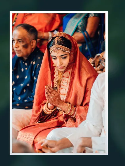 A bride in her beautiful red saree prays during the wedding ceremony, a moment of serene devotion.