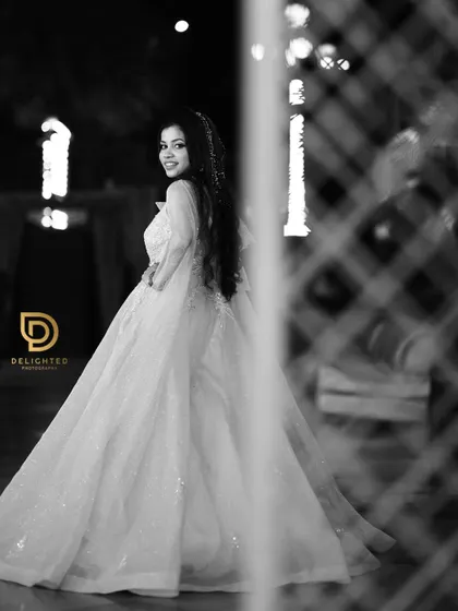 A beautiful black and white shot of the bride-to-be looking over her shoulder, highlighting the elegant silhouette of her engagement gown.