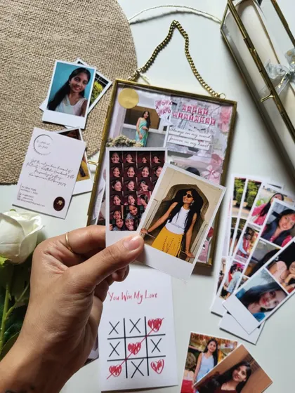 Holding up a polaroid before adding it to the frame. Each photo is carefully chosen and placed to create the perfect composition.