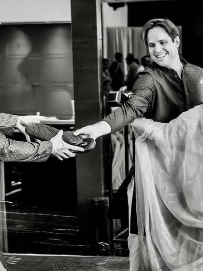 The groom's brother successfully negotiates to get the shoes back from the bride's sister, a fun moment of family banter.