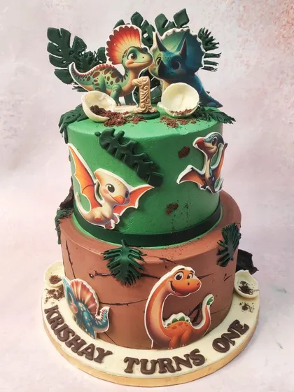We go back in time with this adventurous two-tiered dinosaur cake. The design combines a green jungle tier with a brown, earthy tier, both decorated with various baby dinosaurs and prehistoric foliage for a one-year-old's first big adventure.
