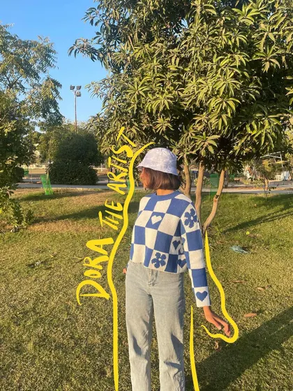 Dora the artist. A fun nickname for myself, doodled onto a photo of me in a park.