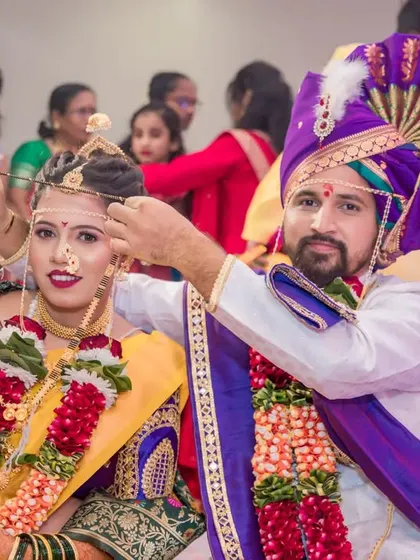 The groom places the mangalsutra on the bride, a pivotal and emotional moment in their wedding.
