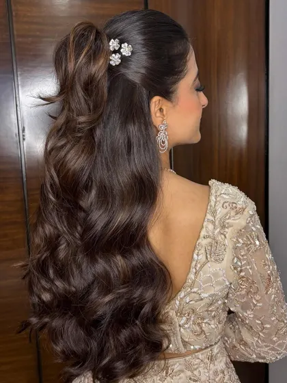 A glamorous high ponytail with soft, bouncy waves. This style is perfect for a Sangeet or cocktail party, combining elegance with a fun, youthful vibe.