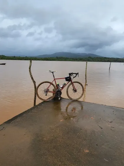 A bike stands on a jetty against the backdrop of the monsoon-swollen backwaters of Gokarna. The dramatic scenery makes for incredible cycling and photography.