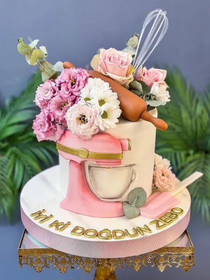 Another angle of the adorable baker-themed cake, showing the beautiful floral arrangement.