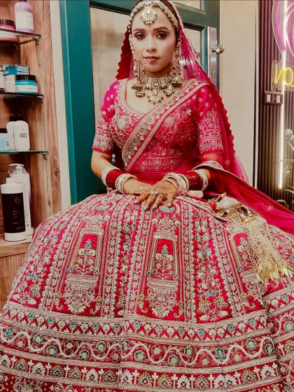 A glimpse into our bridal magic. Here is a stunning bride in a traditional red lehenga, showcasing our complete bridal service with flawless makeup and elegant hair, ensuring she looks perfect on her big day.