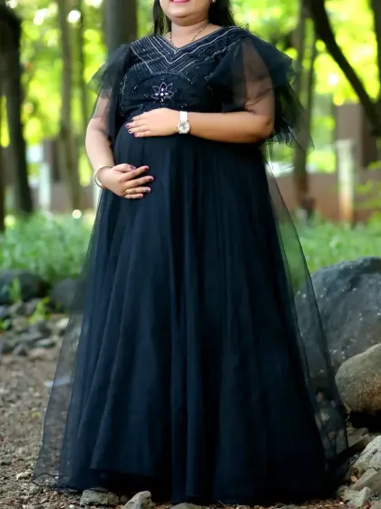 For a classic and sophisticated look, this black maternity gown with delicate handwork on the bodice is an excellent choice. The fluttery cape-like sleeves add a touch of elegance.