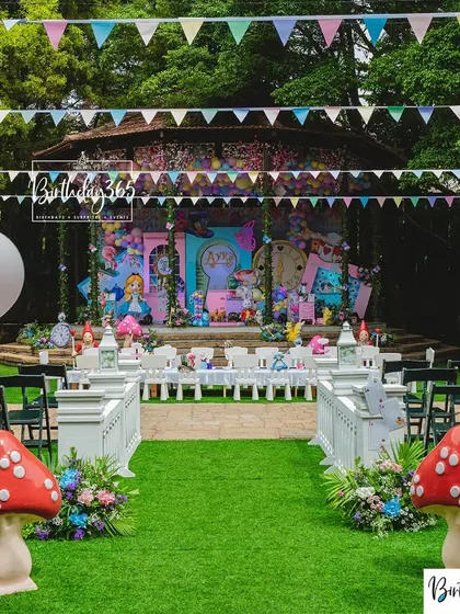 An overview of our Alice in Wonderland party, set in a beautiful outdoor amphitheater. We created a whimsical path with giant mushrooms leading to a fully decorated stage, complete with character props and themed dining for the kids.