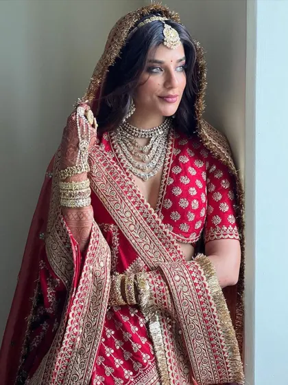 A classic bridal look will always have my heart. Here, the beautiful Carla Dennis is a vision in a traditional red Sabyasachi lehenga, paired with an incredible multi-layered polki necklace. This look is all about timeless elegance and regal grace.