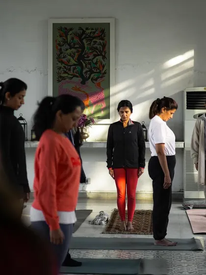 A group of dedicated students standing in 'Tadasana' (Mountain Pose). This foundational pose is the starting point for building balance, stability, and body awareness.