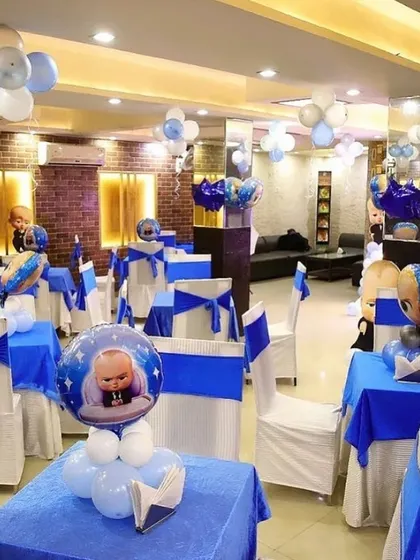The dining area of a Boss Baby themed party, with themed centerpieces and chair covers.