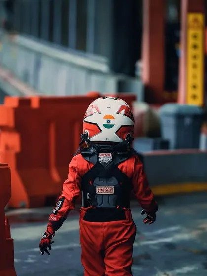 A young driver walking through the pit lane at the Rok Cup Singapore.