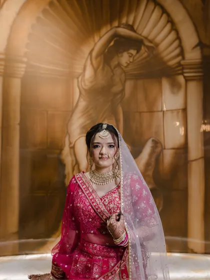 A bridal portrait with an artistic touch, the bride posing in front of a classical-style mural, blending art with tradition.