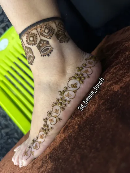 A delicate and minimalist foot design. This 'bel' or trail of flowers along the side of the foot, paired with a simple anklet, is perfect for a subtle, chic look.