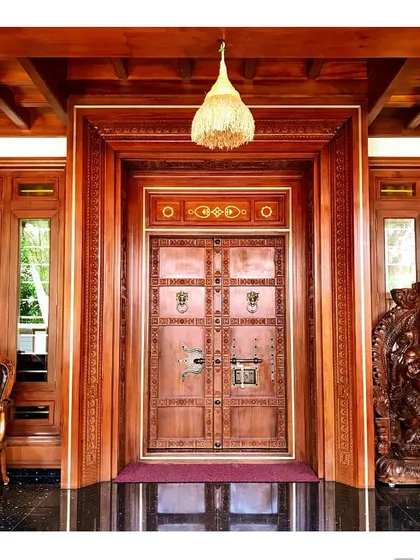 This intricately carved main door is a testament to our deep appreciation for traditional Kerala craftsmanship. We collaborate closely with master artisans to create authentic, detailed woodwork that becomes the soul of a home.