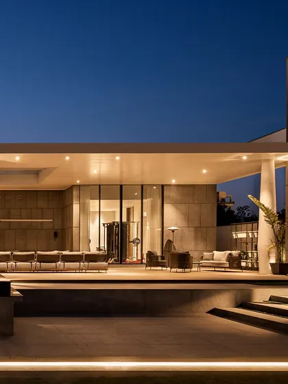 The covered patio at the Ananda residence is an extension of the indoor living space. It offers a comfortable, sheltered area to enjoy the poolside view and the tranquility of the backyard, day or night.