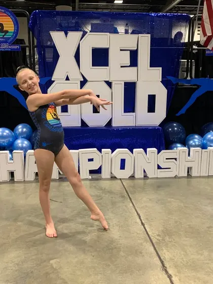 An Xcel Gold athlete strikes a beautiful pose at the regional championships in Arkansas. Her floor routine earned a champion title!