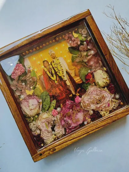 From the wedding aisle to a forever keepsake. This 8x8 inch teakwood frame with LED lighting preserves a wedding garland, creating a stunning glow.