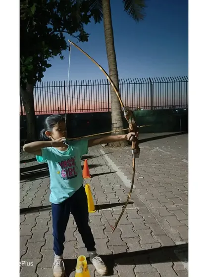A young girl takes aim, showing the determination of our students.