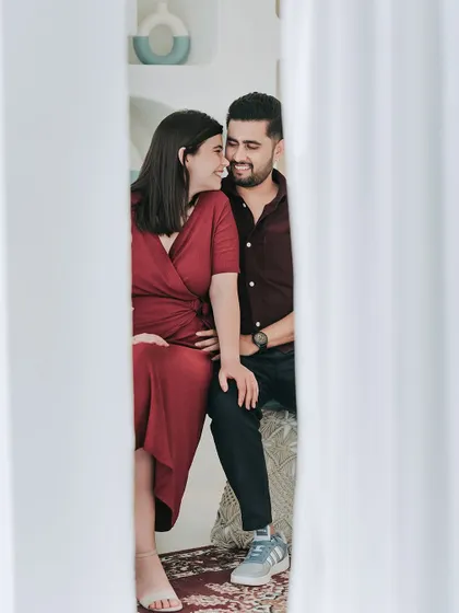 A creative shot peeking through white curtains, capturing an intimate and private moment between the couple.