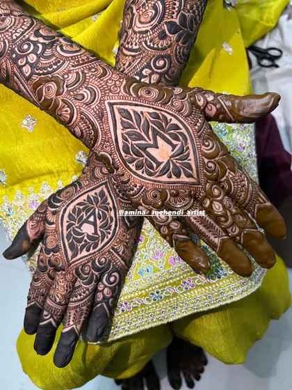 A different pose showing the beautiful symmetry and detail of the personalized 'AM' mehendi design.