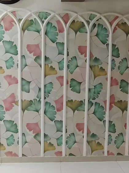 A colorful ginkgo leaf wallpaper installed within a series of decorative white arches. This creative application turns a simple wall into a unique architectural feature.