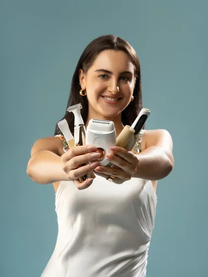 Showcasing a collection of grooming tools. The model presents the products to the camera, giving a clear view of each item. This style of shot is effective for demonstrating product variety and use.