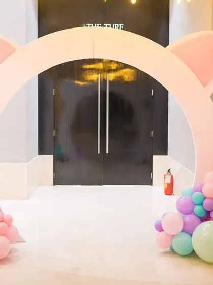The entrance to the kitten party features a large arch shaped like cat ears, decorated with pastel balloons.