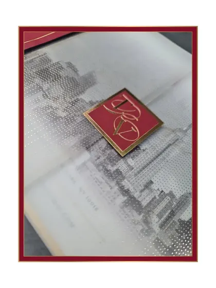 A detailed shot focusing on the custom monogram tag and the textured print of the NYC skyline on vellum.