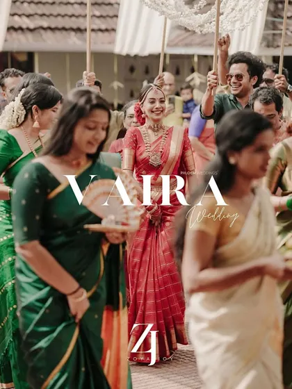 The bride's grand entrance at her Kerala wedding. The image captures the celebratory atmosphere and the beauty of her traditional red saree.