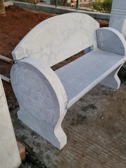 A decorative stone bench with carved floral patterns on the sides, showcasing my team's craftsmanship.
