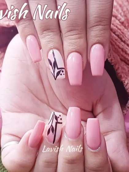 A simple yet stylish set of pink square nails with a black abstract botanical design on the accent nails.