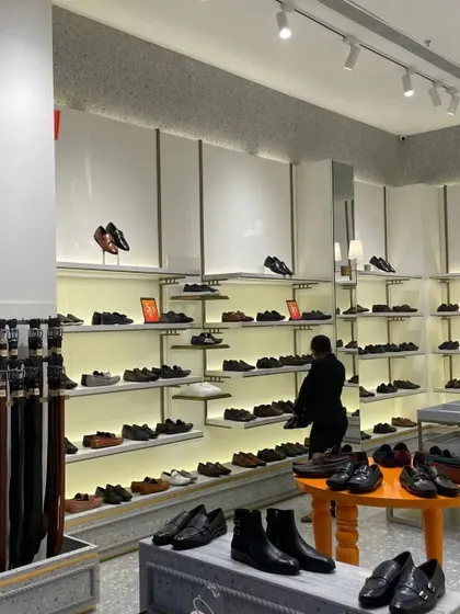 The men's shoe section, with clean, backlit shelves that make the product the hero.