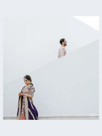 An artistic and minimalist portrait of the couple in Doha, using the clean white architecture to create a striking composition.
