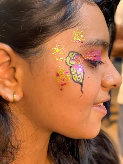 A whimsical butterfly design with a mix of pink, yellow, and lots of gold glitter.