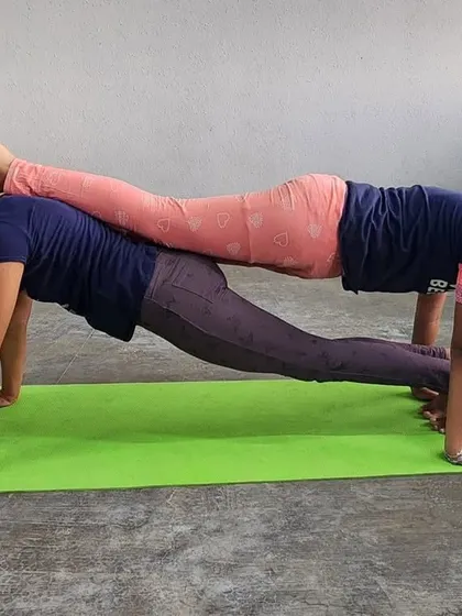 This double plank pose shows the strength and stability of our female campers, proving that acro-yoga is for everyone.