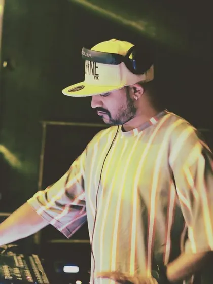 Caption this expression. A candid shot from behind the decks, caught in a moment of concentration or reaction.
