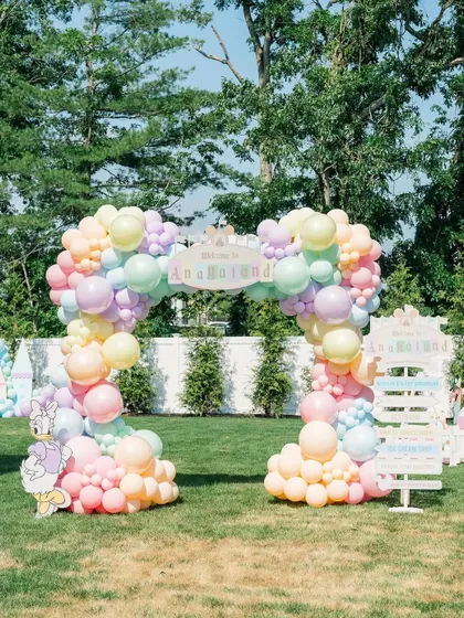The entrance to "Anayaland," featuring a pastel rainbow balloon arch and a custom welcome sign, setting the stage for a magical Disney adventure.
