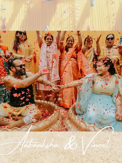A beautiful shot of the couple during their joint Haldi ceremony, being showered with rose petals by their loved ones. The image is full of happiness and color.