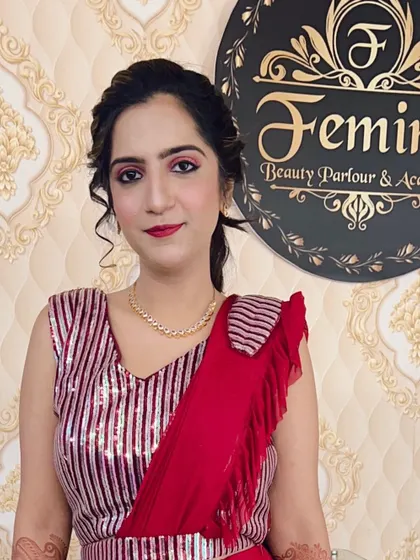 A chic party look with a modern saree-style outfit. The makeup features pink smokey eyes and a simple ponytail hairstyle.